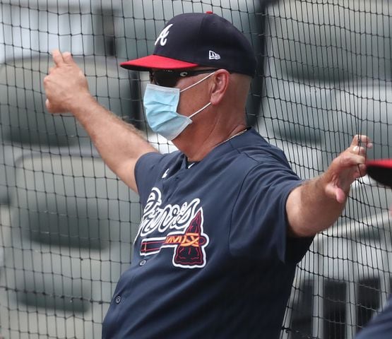Braves manager Brian Snitker watches from behind a net.  Curtis Compton ccompton@ajc.com