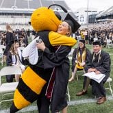 Kelsey Watkins gets a hug from Georgia Institute of Technology's mascot Buzz before the start of the commencement ceremony on Saturday, May 6, 2023. (Steve Schaefer/steve.schaefer@ajc.com)