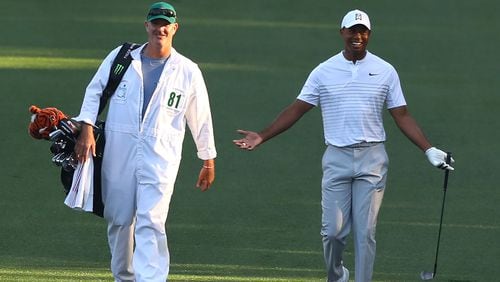 Tiger Woods laughs with his caddy walking down the 10th fairway during his practice round at Augusta National Golf Club on Tuesday, April 3, 2018, in Augusta.  Curtis Compton/ccompton@ajc.com