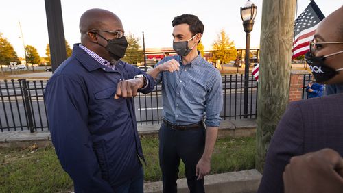 Democratic candidates for U.S. Senate Jon Ossoff and Raphael Warnock, left, elbow bump after a meet and greet with supporters at the Cobb Civic Center on Sunday, Nov.15, 2020, in Marietta, Ga. (JOHN AMIS FOR THE ATLANTA JOURNAL-CONSTITUTION)