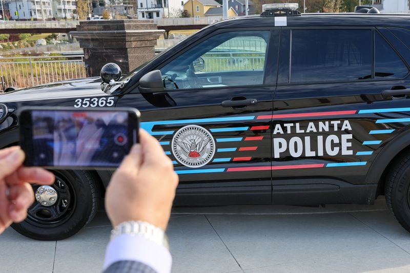A bystander films the redesigned Atlanta patrol car Wednesday, November 2, 2022. The department has launched a take-home car program that city officials hope will deter crime while boosting officer morale. (Arvin Temkar / arvin.temkar@ajc.com)