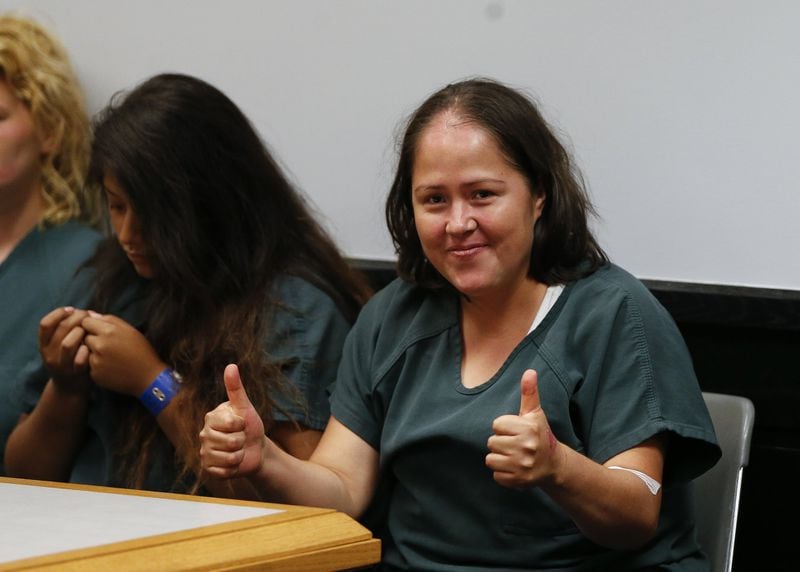 Isabel Martinez gestures towards news cameras during her first court appearance Friday, July 7, 2017, in Lawrenceville , Ga. Martinez is charged with killing four of her children and their father. (AP Photo/John Bazemore)