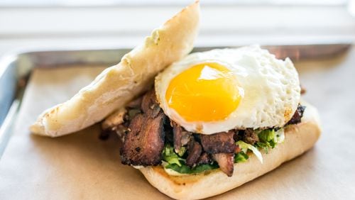 Triple Torta with three kinds of meat, lettuce, avocado aioli, and a fried egg on bread at Porch Light Latin Kitchen. Photo Credit- Mia Yakel. Styling Credit- Chef Andre Gomez