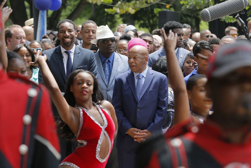 U.S. Rep. John Lewis and Council member Andre Dickens, who introduced the ordinance to honor Lewis, walk, along with supporters and family, behind the Clark Atlanta University band on the way to the unveiling.  