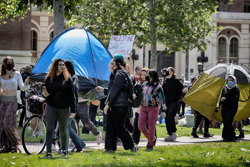 University of Southern California protesters carry a tents around Alumni Park on the campus of the University of Southern California to keep security from removing them during a pro-Palestinian occupation on Wednesday, April 24, 2024 in Los Angeles. (AP Photo/Richard Vogel)