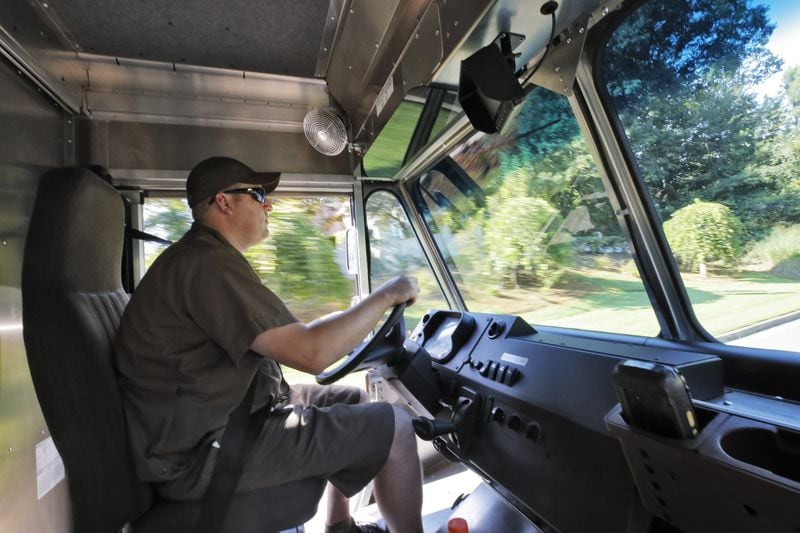UPS driver Dan Partyka heads out on his route. It costs more to deliver items to individual doorsteps, so the rise of online shopping has forced UPS to adjust. BOB ANDRES /BANDRES@AJC.COM