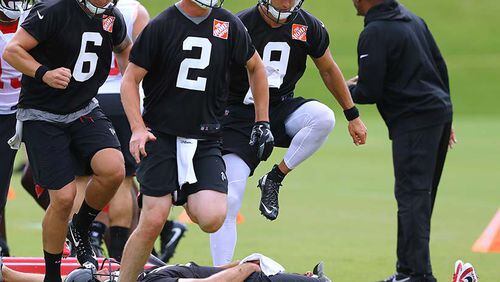 In a leap of faith exercise, Atlanta Falcons backup quarterback Matt Schaub lays on the ground becoming part of an agility drill while quarterbacks Matt Ryan, Kurt Benkert, Garrett Grayson and teammates step over him during the final day of mandatory minicamp Thursday, June 14, 2018, in Flowery Branch.