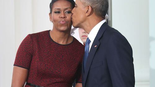 Former President Barack Obama gives a kiss to his wife, former first lady Michelle Obama. (Photo by Mark Wilson/Getty Images)