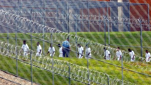Inmates at Lee Arrendale State Prison in Alto walk across the prison yard in this AJC file photo.