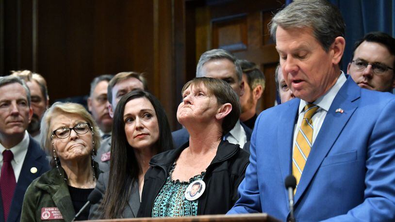 Gov. Brian Kemp introduces anti-gang bills as Deborah Rider (center), who lost her son in a drive-by shooting, tries to hold her tears during a press conference at the Georgia State Capitol building in Atlanta on Thursday, January 30, 2020. (Hyosub Shin / Hyosub.Shin@ajc.com)