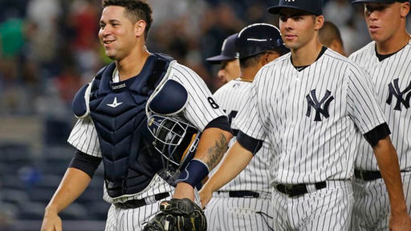 A smiling New York Yankees catcher Gary Sanchez, left, leaves the field with teammates Ben Heller, center, and right fielder Aaron Judge, right, after the Yankees defeated the Baltimore Orioles 14-4 in a baseball game in New York, Friday, Aug. 26, 2016. (AP Photo/Kathy Willens)