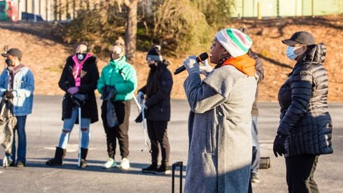 Volunteers gather and listen to instructions from Georgia STAND-UP's executive organizer Ariel Singleton, on microphone, at Impact Church before picking up trash in the in East Point community on Martin Luther King, Jr Day on Monday, January 18, 2021.   (Jenni Girtman for The Atlanta-Constitution)