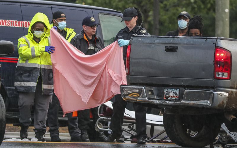  Police investigate a body discovered in the back seat of a pickup truck in the middle of a southwest Atlanta road Aug. 25, 2020. 