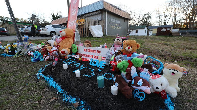 A memorial for 6-month-old Grayson Fleming-Gray is seen outside the Food Mart where he was killed last week in a drive-by shooting. (Curtis Compton / Curtis.Compton@ajc.com)