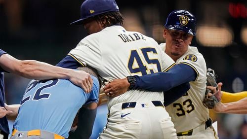 Milwaukee Brewers' Abner Uribe (45) is held back by Quintin Berry (33) as he fights with Tampa Bay Rays' Jose Siri (22) during the eighth inning of a baseball game Tuesday, April 30, 2024, in Milwaukee. (AP Photo/Aaron Gash)