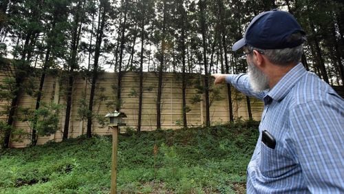 Dovid Antopolsky, a member of Congregation Beth Tefillah, shows the eruv boundary that synagogue members set up on GA-400 sound wall on Friday, August 3, 2018. The 400-285 construction has had an impact on the Jewish communities in Dunwoody and Sandy Springs. They had used highway sound walls, fences and power lines to form an eruv, a boundary that allows community members to carry anything from their car keys to their children on the Sabbath. When construction started, the group had to work with DOT to figure out how to keep the eruv intact while allowing the work to go on. HYOSUB SHIN / HSHIN@AJC.COM
