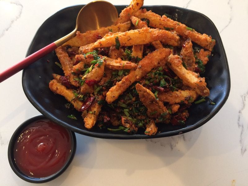 Battered Sichuan potato wedges are stir-fried with generous amounts of garlic, dried chiles, numbing Sichuan peppercorns, ground cumin and cilantro. CONTRIBUTED BY WENDELL BROCK