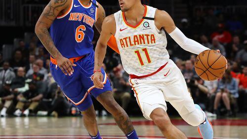 Hawks guard Trae Young drives against New York Knicks guard Elfrid Payton in a NBA basketball game on Wednesday, March 11, 2020, in Atlanta. As the country grapples with coronavirus and how to best combat the spread of the disease, athletic teams and organizations are asking themselves that same question.   Curtis Compton ccompton@ajc.com