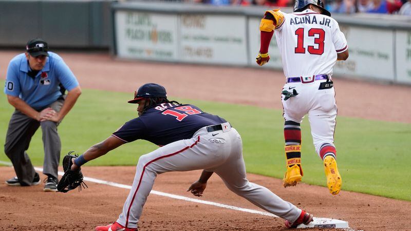 Braves outfielder Ronald Acuna (13) beats the throw to Washington Nationals first baseman Josh Bell (19) for an infield single in the first Inning Monday, May 31, 2021, at Truist Park in Atlanta. (John Bazemore/AP)
