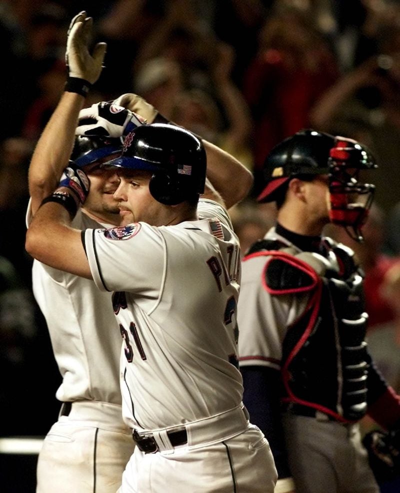 Braves catcher catcher Javy Lopez (right) steps aside as New York Mets' Mike Piazza is greeted by teammate Robin Ventura after Piazza's two-run home run in the eighth inning against the Braves at Shea Stadium in New York, Friday, Sept. 21, 2001. The Mets beat the Braves, 3-2. (Jeff Zelevansky/AP)