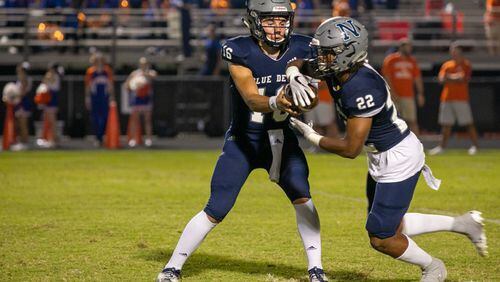 Norcross' Mason Kaplan (16) hands off the ball to Norcross' Kaleb Jackson (22) during Friday's game. (Rebecca Wright/For the AJC)