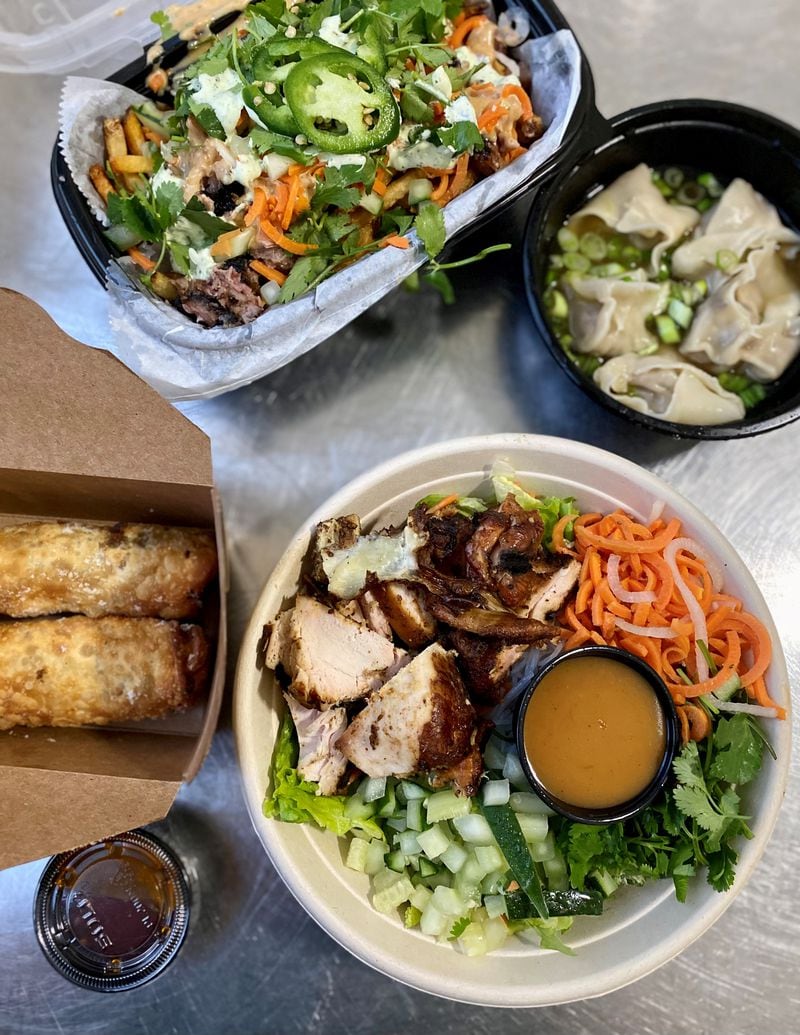 This takeout order from Pho Cue includes loaded fries dressed up with banh mi toppings, dumplings filled with pork barbecue, vermicelli salad with smoked chicken, and egg rolls with brisket. Wendell Brock for The Atlanta Journal-Constitution