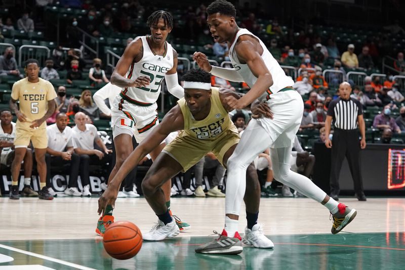 Georgia Tech forward Jordan Meka (23) lunges for a loose ball against Miami guard Kameron McGusty (23) and forward Anthony Walker during the first half Wednesday in Coral Gables, Florida. (AP Photo/Wilfredo Lee)