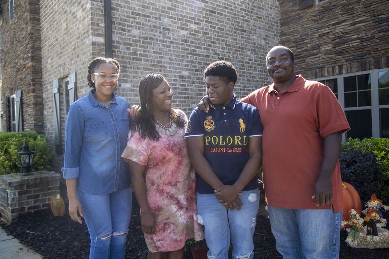 Samanthia Jordan-Hill, second from left, poses for a photo with her husband, Norman Hill, right, her daughter Kristen Jordan, left, and adopted son Christian Jordan at their residence in Newnan, Wednesday, October 7, 2020. It took the family two years to finalize Christian's adoption. (Alyssa Pointer / Alyssa.Pointer@ajc.com)