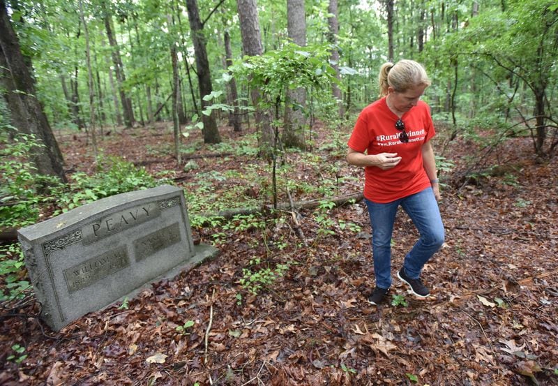 Joell Brule walks by graveyard in proposed the rezoning area in Dacula on Tuesday, June 12, 2018. HYOSUB SHIN / HSHIN@AJC.COM