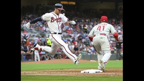 Lane Adams of the Braves beats the throw to Phillies first baseman Carlos Santana for a single during the seventh inning of a baseball game Thursday, March 29, 2018, in Atlanta. (Curtis Compton/Atlanta Journal-Constitution via AP)