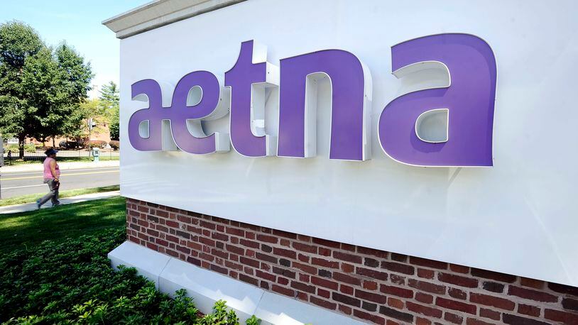 In this Tuesday, Aug. 19, 2014, photo, a pedestrian walks past a sign for Aetna Inc., at the company headquarters in Hartford, Conn. Aetna will become the latest health insurer to chop its participation in the Affordable Care Act’s public exchanges when it trims its presence to four states for 2017, from 15 this year. The nation’s third-largest insurer said late Monday, Aug. 15, 2016, that a second-quarter pre-tax loss of $200 million from its individual insurance coverage helped it decide to limit exposure to the exchanges, which also have generated losses for UnitedHealth Group and Anthem, among other carriers. (AP Photo/Jessica Hill)