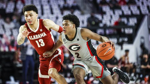 Georgia sophomore guard Sahvir Wheeler (2) drives on Alabama's Jahvon Quinerly on Saturday, March 6, 2021, at Stegeman Coliseum in Athens. Wheeler logged another 'double-double' with 18 points and 10 assists, but the Bulldogs fell to the No. 8-ranked Crimson Tide 89-79. (Photo by Tony Walsh/UGA Athletics)