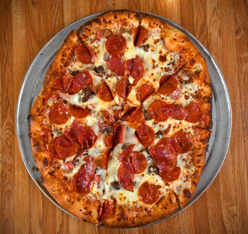 The Sid Vicious pizza at Shorty’s is topped with sausage, ground beef, Black Forest ham, salami and pepperoni. (Chris Hunt for The Atlanta Journal-Constitution)