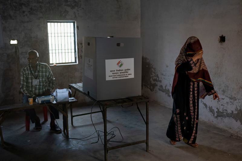 A woman returns after casting her vote during the third round of voting in the six-week-long general election in Agra, Uttar Pradesh, India, Tuesday, May 7, 2024. (AP Photo/Altaf Qadri)