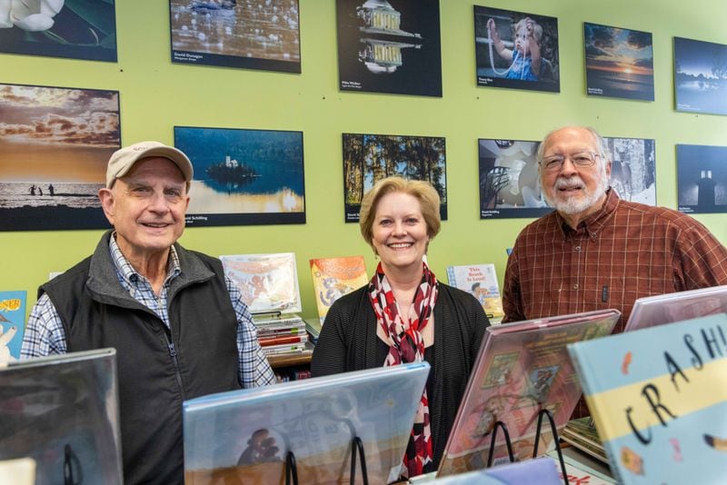 Peachtree Corners Photography Club members David Schilling (from left), Tracey Rice and Richard Phillips stand with some of their work on display at the Peachtree Corners Branch Library. PHIL SKINNER FOR THE ATLANTA JOURNAL-CONSTITUTION