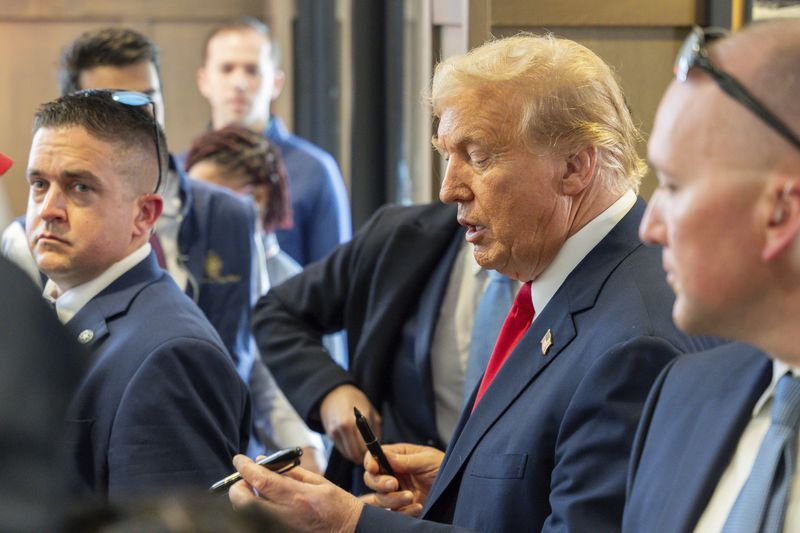 Republican presidential candidate former President Donald Trump, center, visits a Chick-fil-A eatery, Wednesday, April 10, 2024, in Atlanta. (AP Photo/Jason Allen)