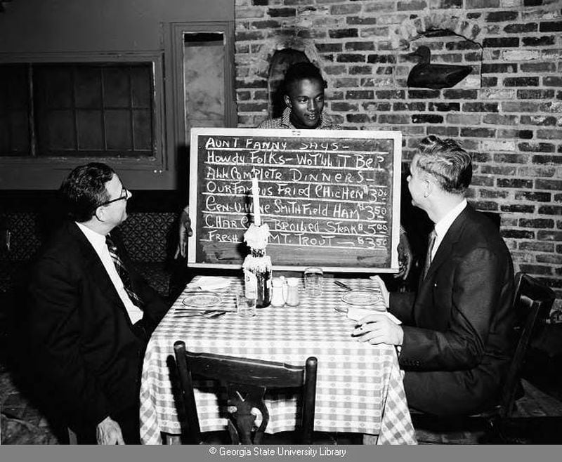 1956 – A server shows diners a blackboard of the day’s offerings. LANE BROS. COMMERCIAL PHOTOGRAPHS / GSU