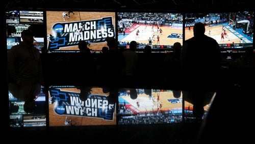 People watch coverage of the first round of the NCAA college basketball tournament at the Westgate Superbook sports book in Las Vegas. The Supreme Court has struck down a federal law that bars gambling on baseball, basketball, football and other sports in most states, giving states the go-ahead to legalize betting on sports. (AP Photo/John Locher)