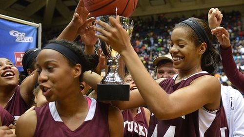 Tucker's Erykah Davenport (44) holds the game ball and championship trophy during the awards ceremony after their Class AAAAA title win over Southwest Dekalb Friday, March 7, 2014, in Macon. (Kent D. Johnson / AJC)