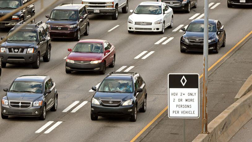 A Lexus SUV travels in the HOV lane as other vehicles are shown in much slower additional lanes on I-85 south approaching the I-75/I-85 connector during rush hour traffic.