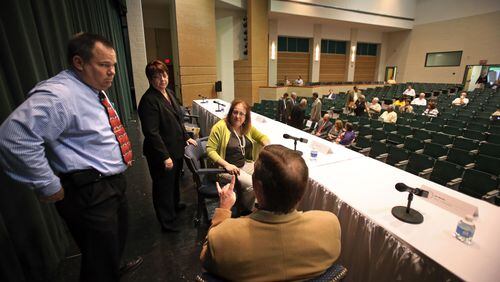 Gwinnett County Board of Commissioners, from left, Tommy Hunter, Chair Charlotte Nash, Lynette Howard, and Jace Brooks, talk before they hold a town hall meeting at Grayson High School Wednesday night in Loganville, Ga.