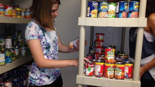 Georgia State University senior Diana Parker reads a label on a can of beans at the downtown campus’ new food pantry. Parker is one of the student volunteers at the pantry. Gracie Bonds Staples/gstaples@ajc.com