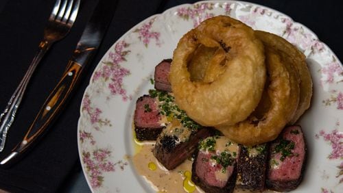 Tavern steak au poivre with onion rings at Golden Eagle, served on kitschy china befitting the restaurant’s theme. CONTRIBUTED BY HENRI HOLLIS