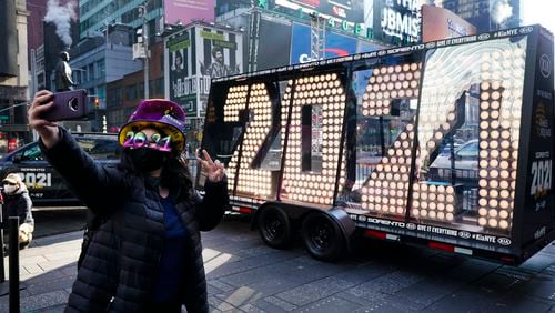 Teresa Hui, 39, poses for selfie photographs in front of the giant numerals for "2021" to be used in the upcoming New Year's eve festivities in New York's Times Square, Monday, Dec. 21, 2020. (AP Photo/Frank Franklin II)