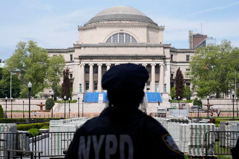 A New York City police officer looks over the center of Columbia University, the usual site of a large graduation ceremony, in New York, Monday, May 6, 2024. The university says it is canceling its university-wide commencement ceremony following weeks of pro-Palestinian protests. Smaller school-based ceremonies are still on for this week and next. (AP Photo/Seth Wenig)