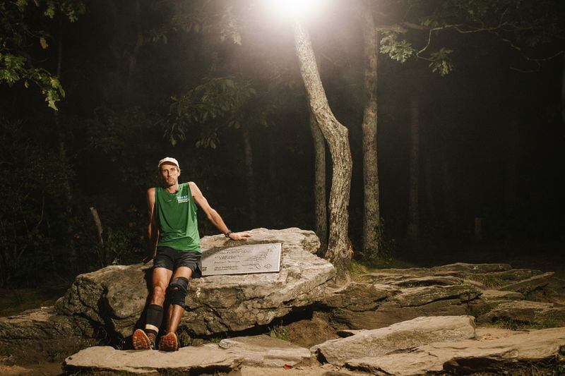 Karl Meltzer, ultra-runner, rests against the plaque on the summit of Springer Mountain, after completing the fastest-ever Maine-to-Georgia run. Photo: Carl Rosen/Red Bull