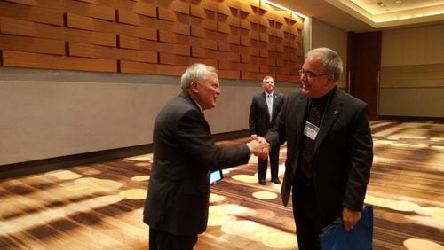 Gov. Nathan Deal shakes hands with Georgia School Superintendent Richard Woods before a recent speech to school leaders last year. Woods wants his department to be in charge of school turnaround efforts, but a bill the governor supports gives that responsibility to an officer who would report to the state school board, which the governor appoints. AJC File photo