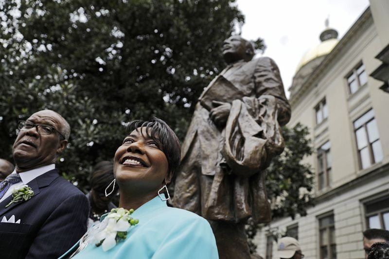 The Rev. Bernice King, right, daughter of the Rev. Martin Luther King Jr., stands under a statue paying tribute to her father, after it’s unveiled on the state Capitol grounds in Atlanta, Monday, Aug. 28, 2017. The statue’s unveiling Monday came more than three years after Georgia lawmakers endorsed the project. A replica of the nation’s Liberty Bell tolled three times before the 8-foot (2.44-meter) bronze statue was unveiled on the 54th anniversary of King’s “I have a dream” speech at the march on Washington. (AP Photo/David Goldman)