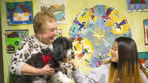 Cynthia Zeldin (left) allows Global Village project student Mu Doe (right) (last name withheld), 15, to pet Lily, a registered therapy dog, during their reading time at the Global Village Project school in Decatur. (ALYSSA POINTER/ALYSSA.POINTER@AJC.COM)