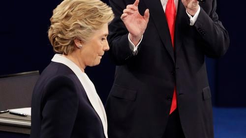 FILE - In this Sunday, Oct. 9, 2016 file photo, Democratic presidential nominee Hillary Clinton walks past Republican presidential nominee Donald Trump during the second presidential debate at Washington University in St. Louis. (AP Photo/John Locher)